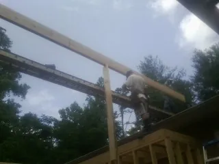 Carpenter setting a ridge beam over a new addition frame — Ice Dam Removal by Roofing Brothers in Bulls Gap