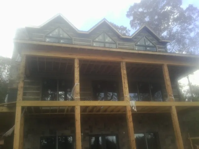 Dormers and porch framing on a large log home under construction — Roof Coating work by our crew in Bulls Gap