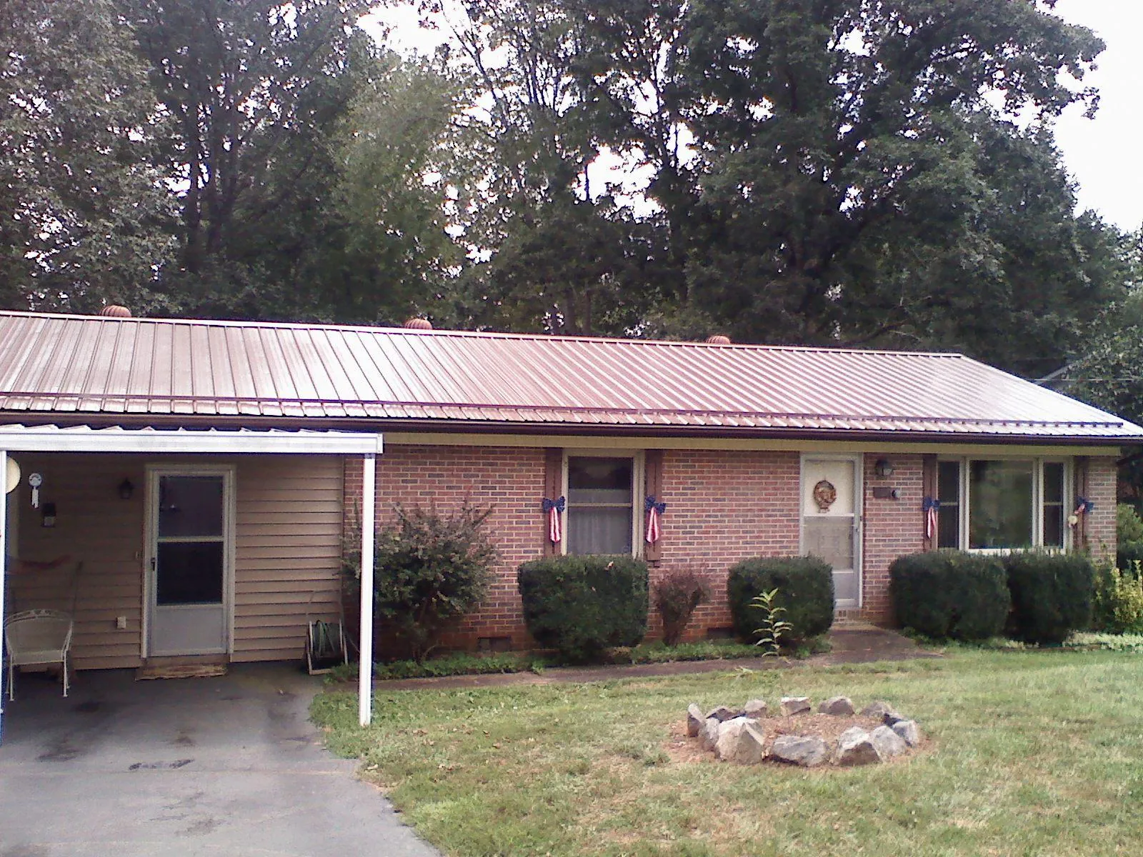 Bronze metal roof and carport on a brick ranch home — Roof Repair work by our crew in Bulls Gap